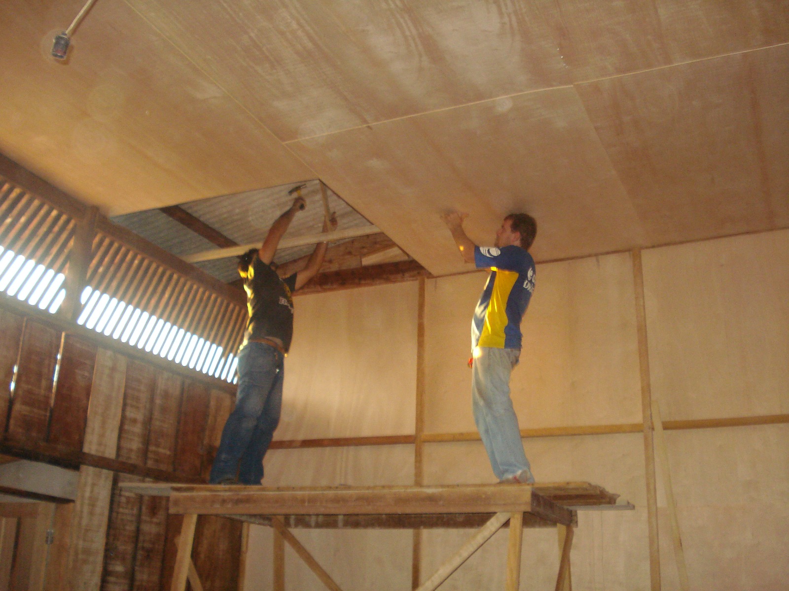 Trabalhadores instalando o forro do prédio da Escola Agrícola Terra Nova